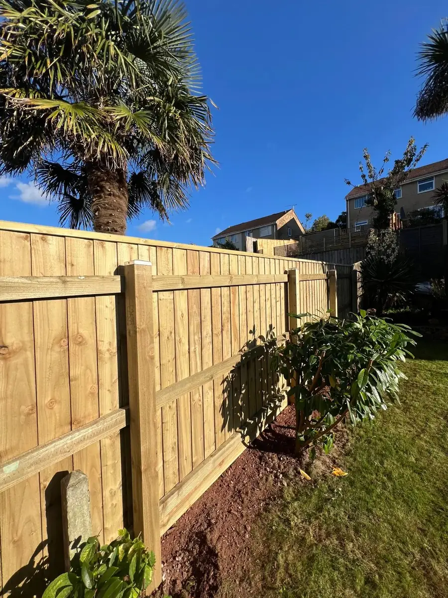 An original concrete boundary post left in place beside the new 6ft featherboard fence in Brixham