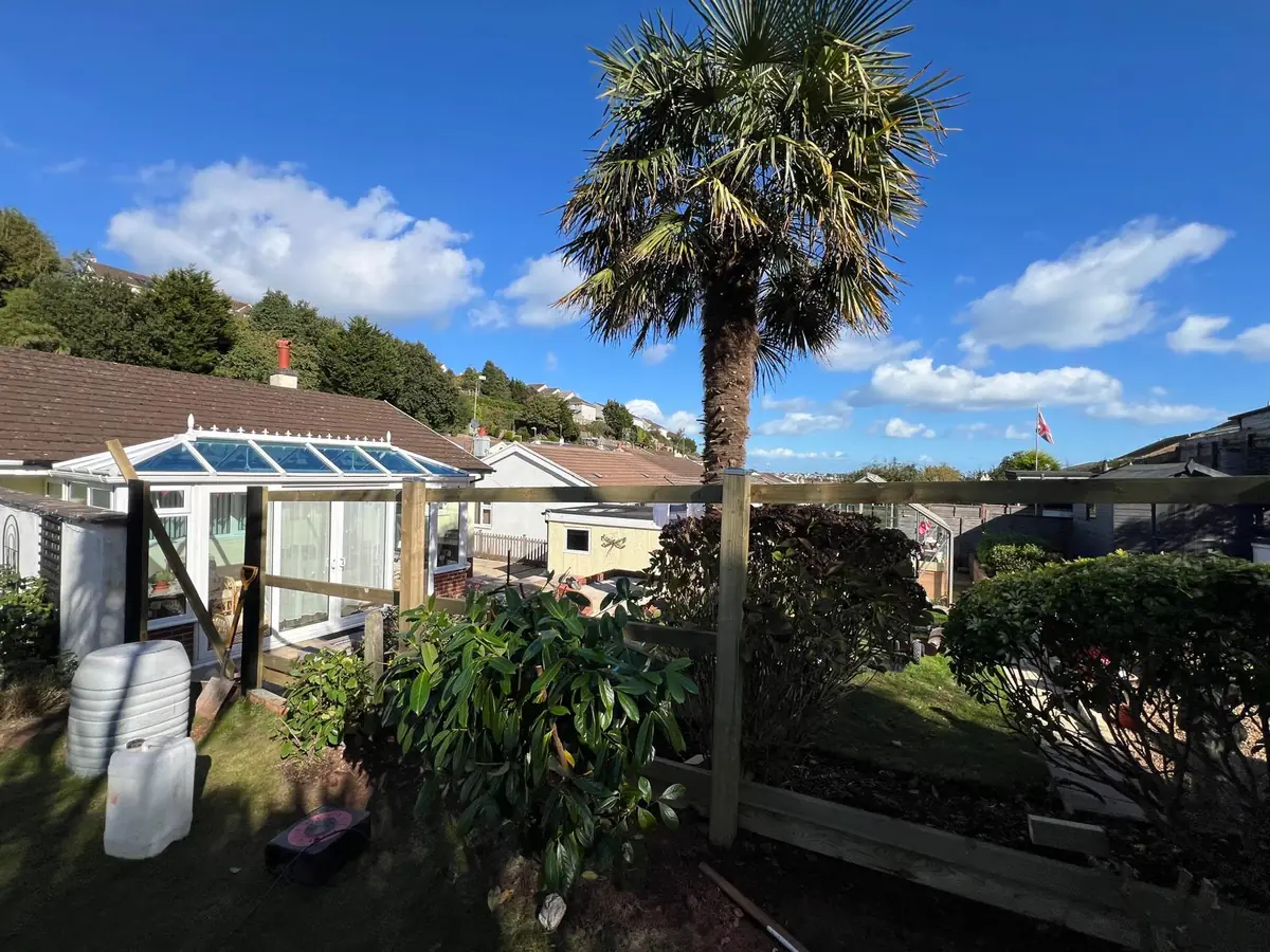 Frame of a new featherboard fence in a Brixham garden, with timber posts and rails ready for boarding