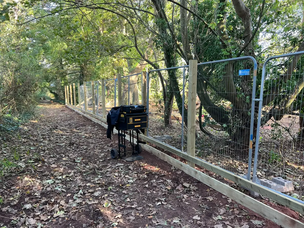 New fence posts and gravel boards along a woodland public footpath in Wellswood, Torquay