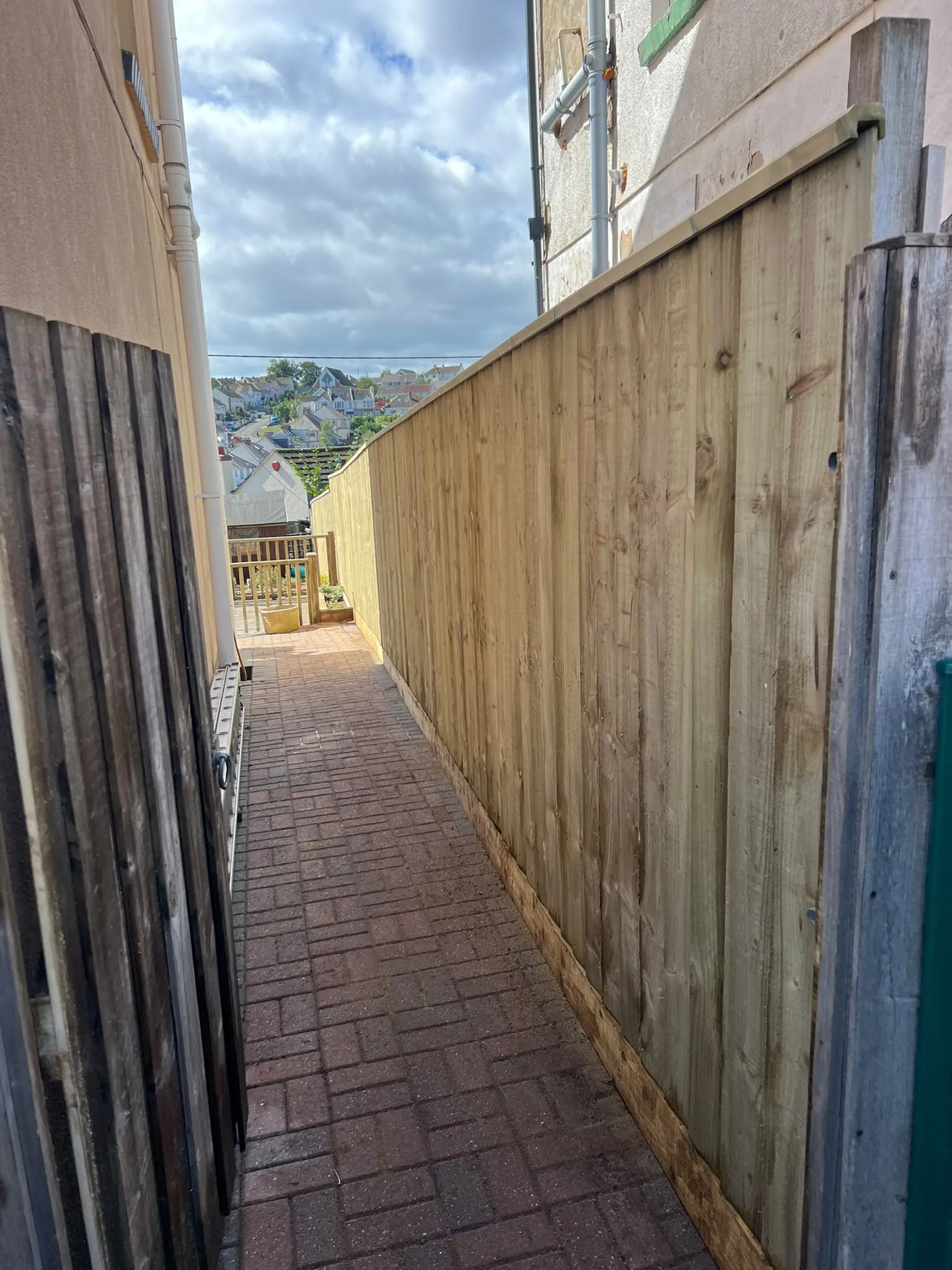 Paignton side-passage closeboard fence with gravel boards and capping rail following a slight rise