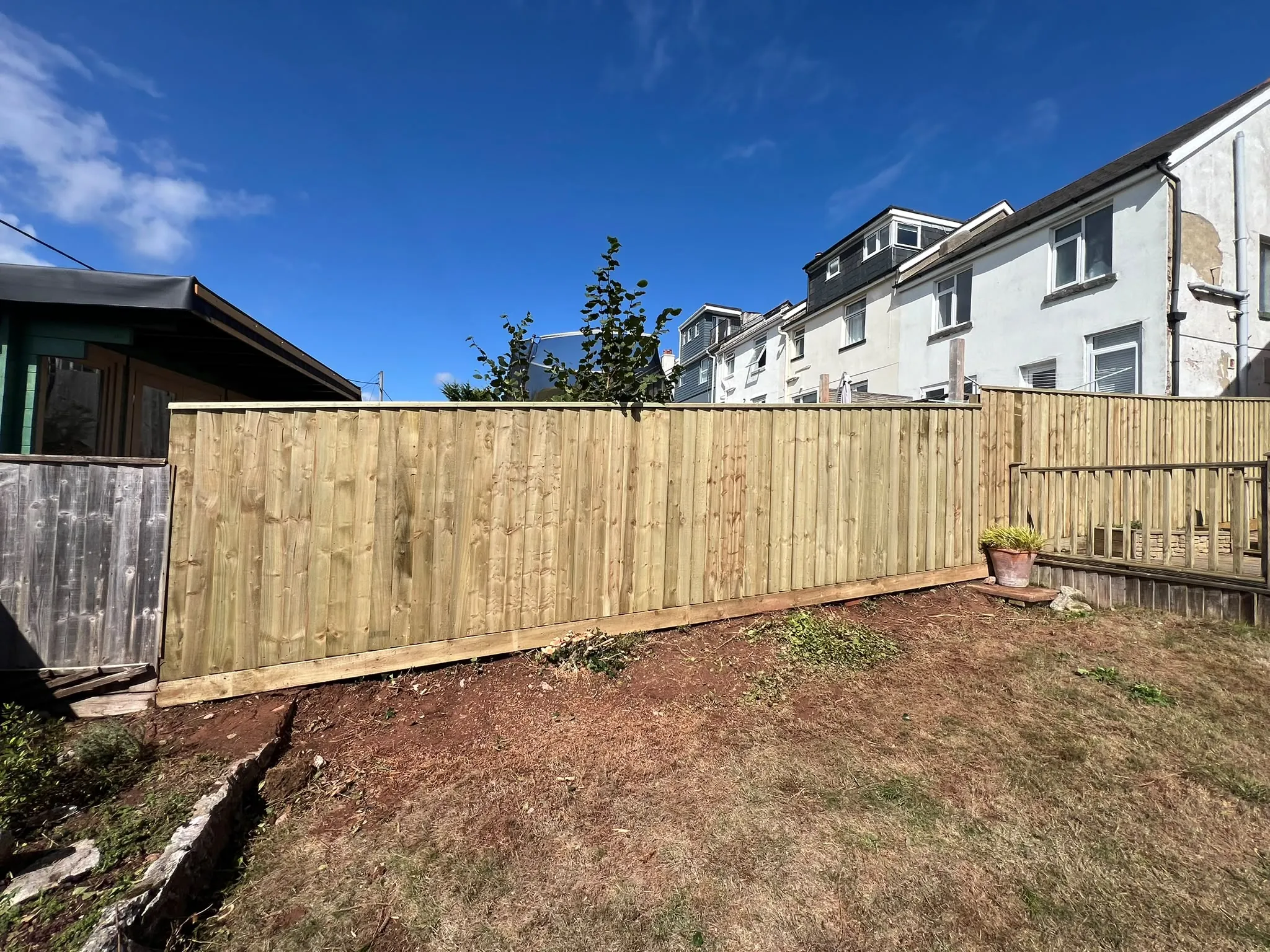 Closeboard fence stepping up a sloping Paignton garden with capping rail
